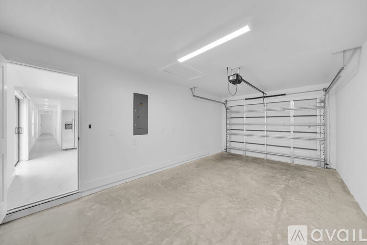 A spacious garage with a white interior and a metal rack on the wall.