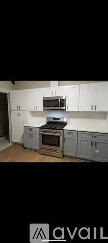 A kitchen with white cabinets and a stove top oven.