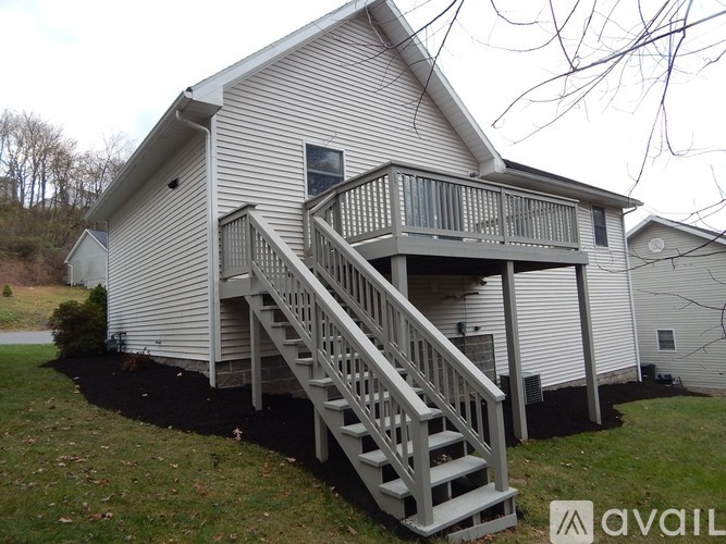A house with a deck and stairs leading to it.