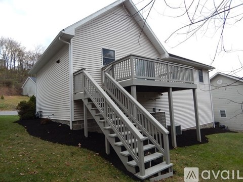 A house with a deck and stairs leading to it.