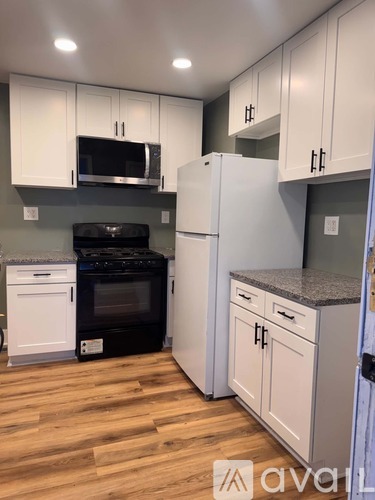 A kitchen with white cabinets and a black oven.