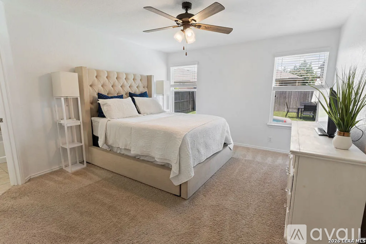 A bedroom with a large bed and a ceiling fan.