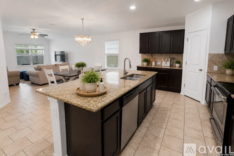 A kitchen with dark brown cabinets and a granite countertop.