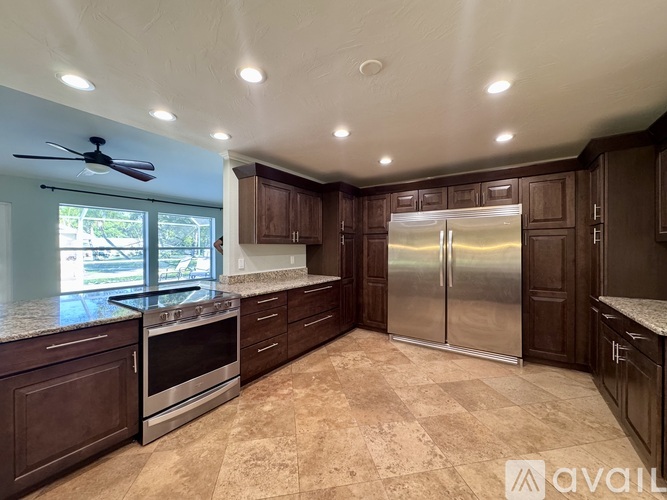 A kitchen with brown cabinets and a tiled floor.
