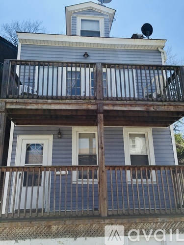A two-story house with a balcony and a satellite dish on the roof.