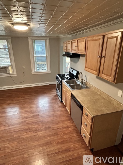 A kitchen with wooden floors and cabinets.