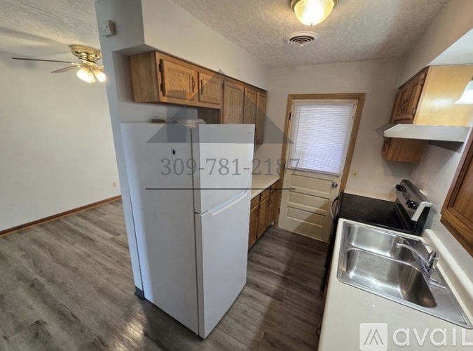 A kitchen with a white fridge and a sink.