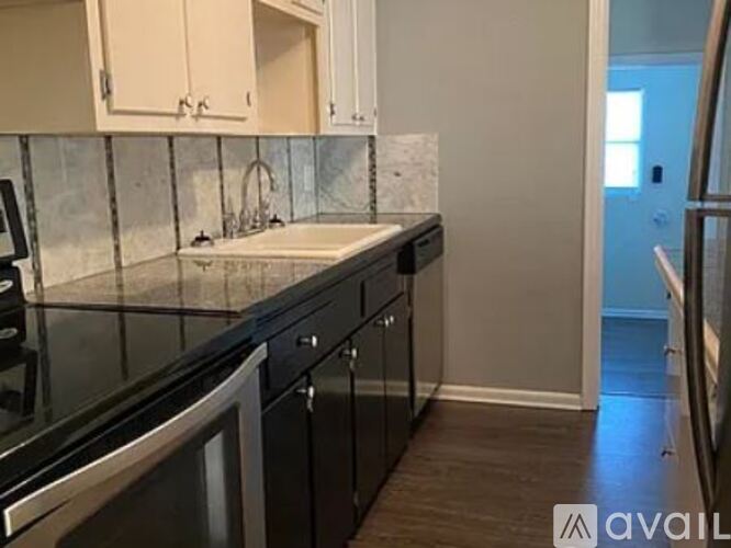 A kitchen with black countertops and stainless steel appliances.