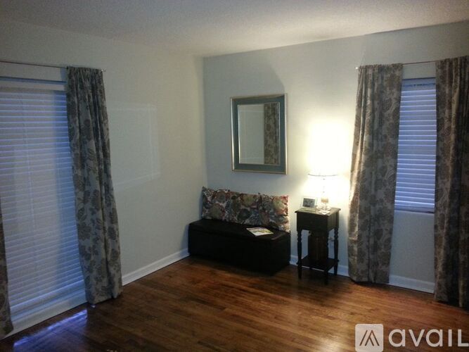 A living room with a couch, a side table, and a mirror.