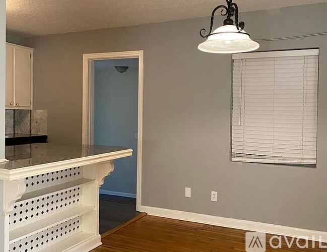 A room with a white shelf and a hanging light fixture.