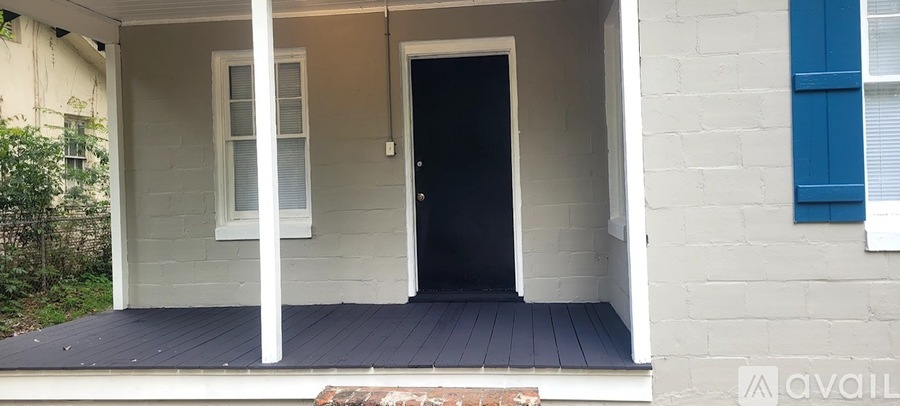 A white house with a black door and a window.
