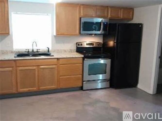 A kitchen with wooden cabinets and black appliances.