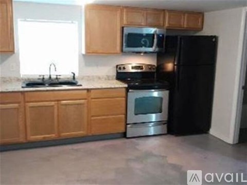 A kitchen with wooden cabinets and black appliances.