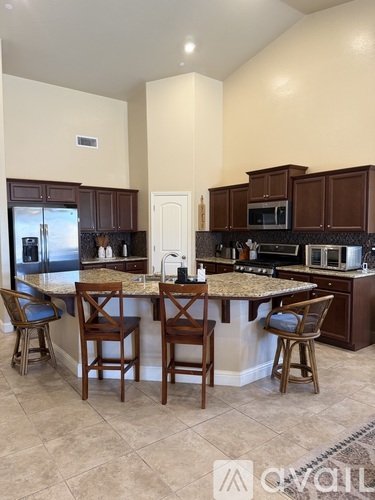 A kitchen with a bar area and chairs.