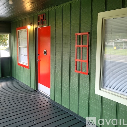 A red door is on the left side of a green wall.