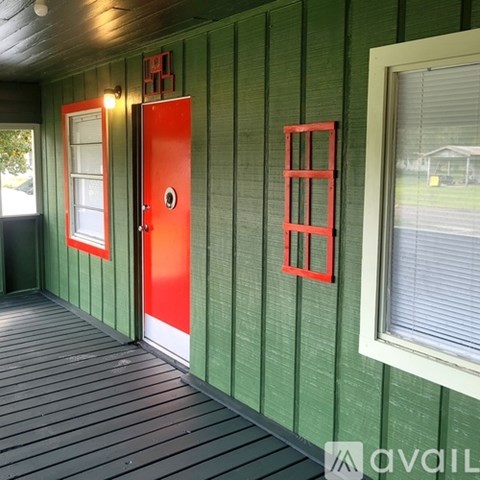A red door is on the left side of a green wall.