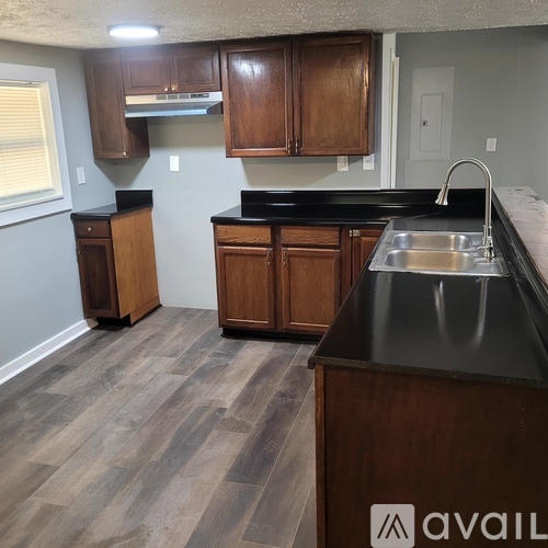 A kitchen with wooden cabinets and a black countertop.