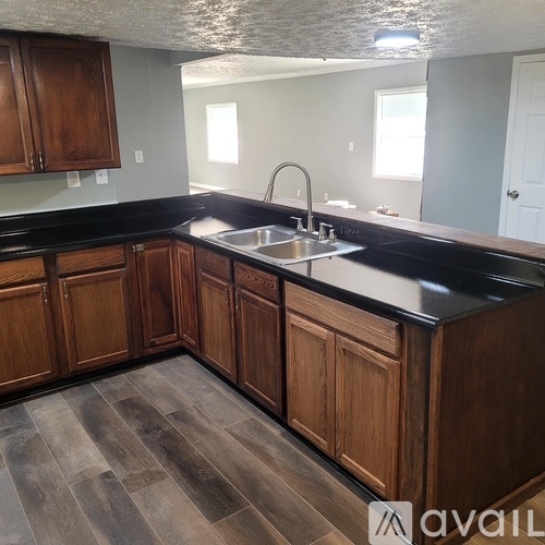 A kitchen with wooden cabinets and a black countertop.