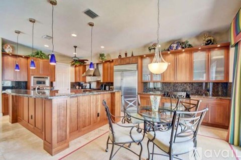 A kitchen with wooden cabinets and a glass table.