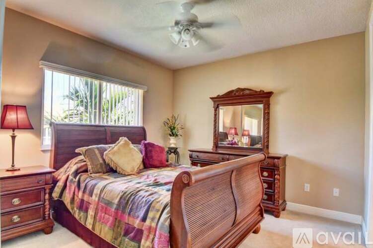 A bedroom with a bed, dresser, and mirror.