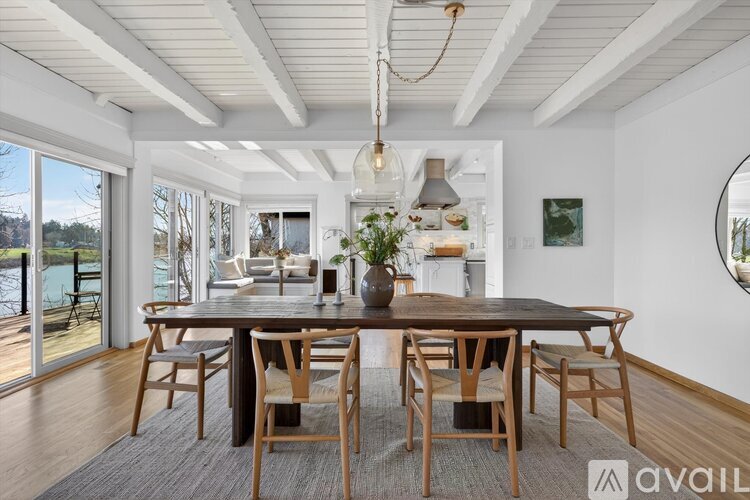 A dining room with a wooden table and chairs.