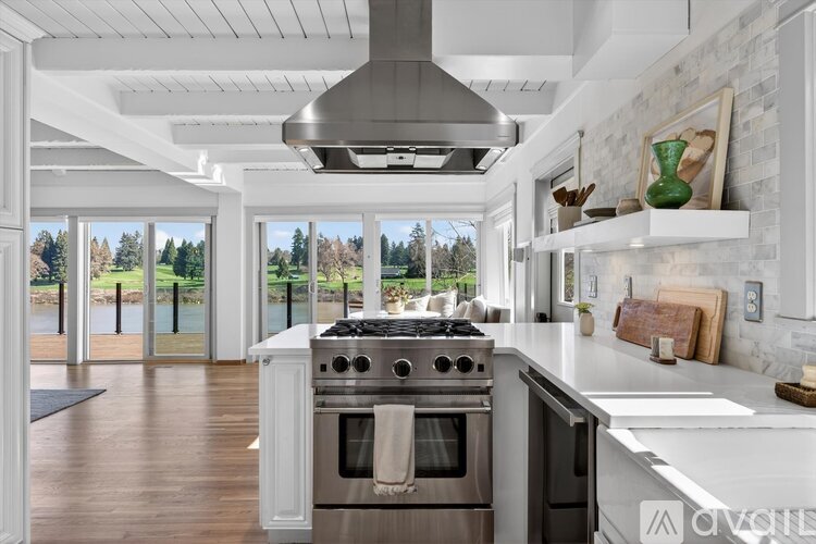 A modern kitchen with a stainless steel range hood and oven.