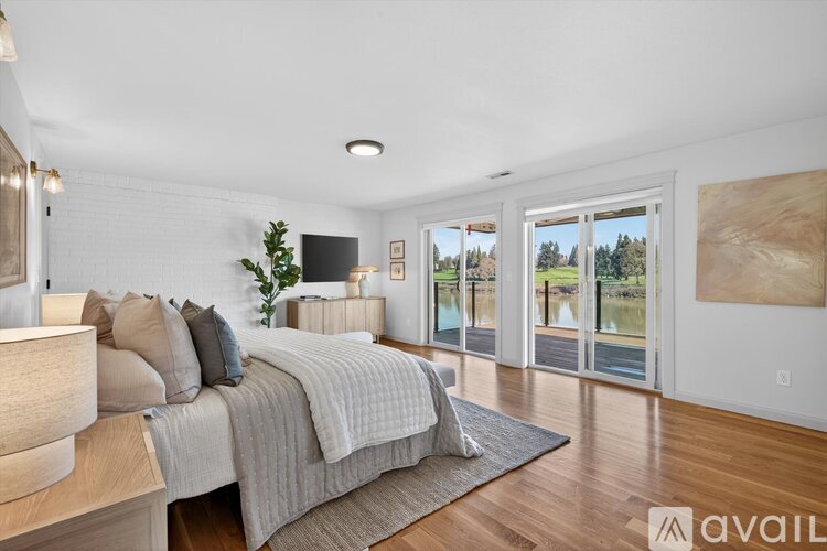 A bedroom with a large bed and a flat screen TV mounted on the wall.
