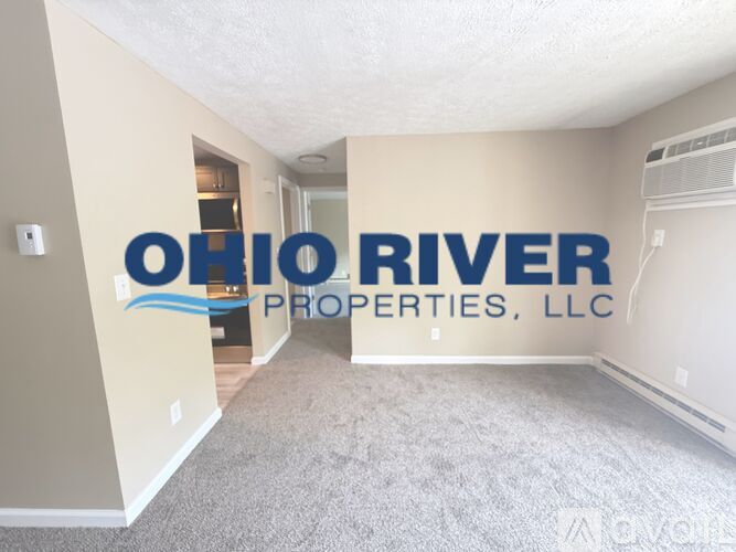 A room with carpeted floor and a wall with a logo for Ohio River Properties, LLC.