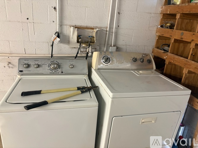 A white washing machine and dryer are in a room with a white wall.