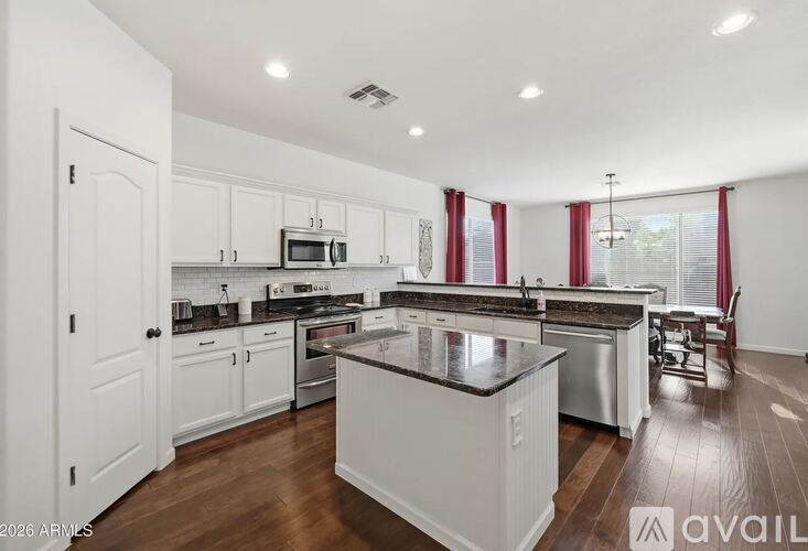 A kitchen with white cabinets and a large island.