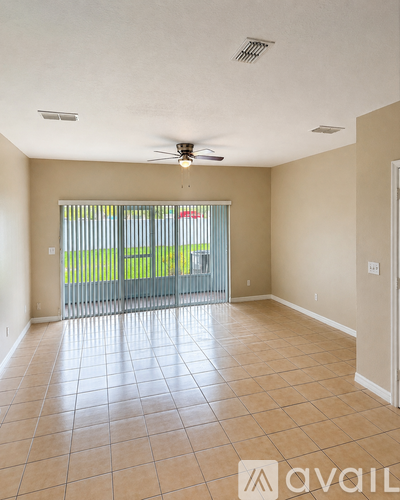 A spacious room with tiled flooring and a ceiling fan.