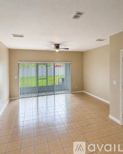 A spacious room with tiled flooring and a ceiling fan.