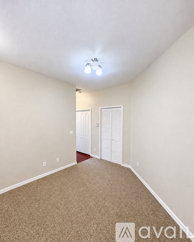 A room with carpeted floor and a white ceiling with a light fixture.