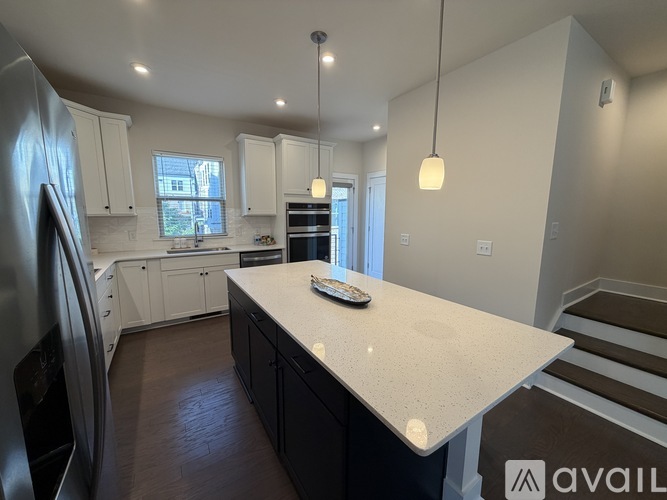 A kitchen with a white countertop and black cabinets.