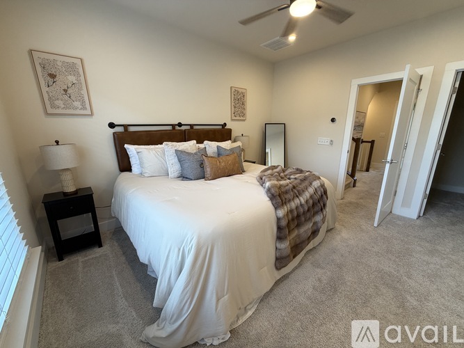 A bedroom with a large bed and a ceiling fan.