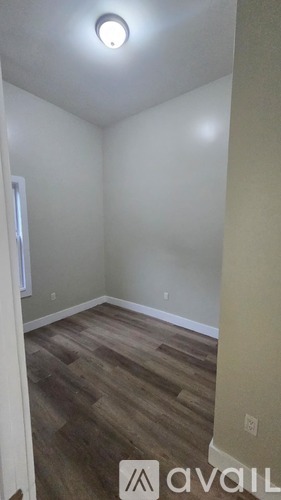 A room with wooden flooring and a ceiling light.
