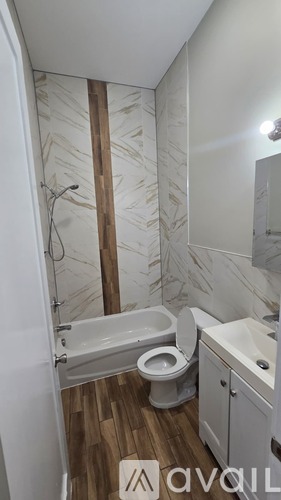 A bathroom with a toilet, sink, and a shower with a glass door.