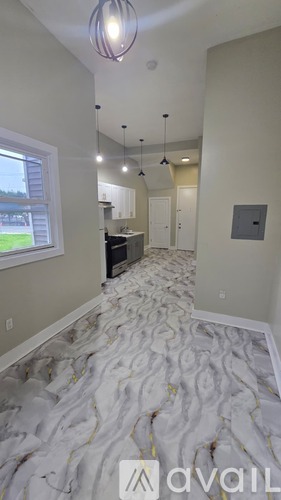 A room with a carpet on the floor and a window on the left side.