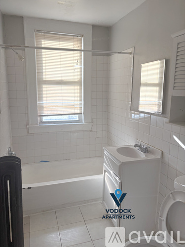 A bathroom with a bathtub, toilet, and sink.