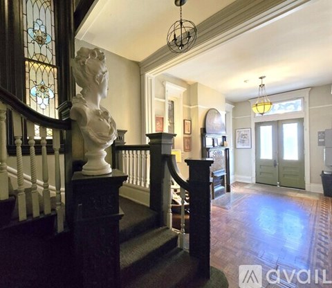 A staircase with a white marble statue on the landing.