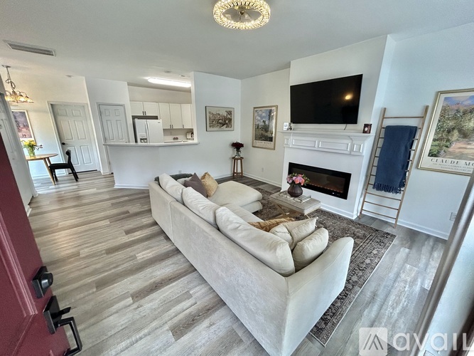 A living room with a white couch and a fireplace.