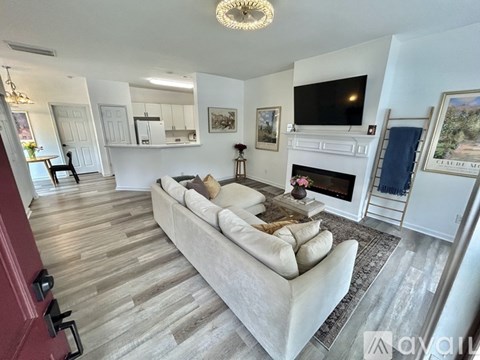 A living room with a white couch and a fireplace.