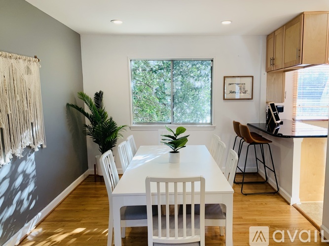 A dining room with a white table and chairs.