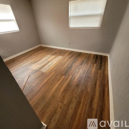 A room with wooden flooring and a window.