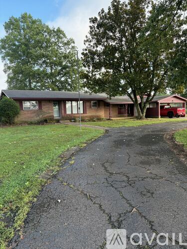 A house with a red car parked in front.