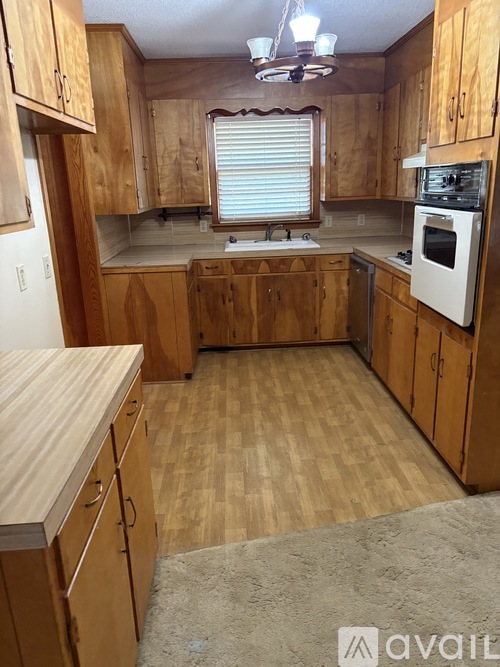 A kitchen with wooden cabinets and a white oven.