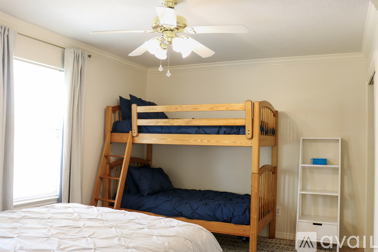 A bedroom with a bunk bed and a ceiling fan.