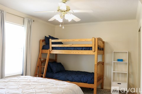 A bedroom with a bunk bed and a ceiling fan.
