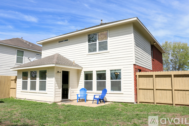 A house with a white exterior and a small porch with two chairs.