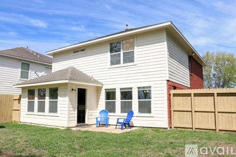 A house with a white exterior and a small porch with two chairs.